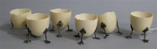 A set of six ivory egg cups, modelled as half egg shells of three chick leg supports, (one a.f.), height 47mm.